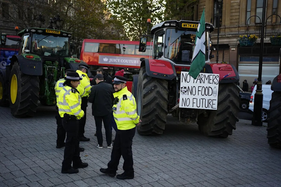 Police officers speak to farmers taking part in the protest (Jordan Pettitt/PA)