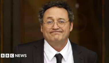 Spanish State Attorney General Alvaro Garcia Ortiz leaves after appearing at the Supreme Court in Madrid. He wears a a dark blazer, white shirt and tie.