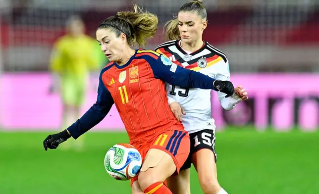 Germany's Selina Cerci and Spain's Alexia Putellas, left, fight for the ball during the women's nations league soccer match between Germany and Spain in Kaiserslautern, Germany, Friday Nov. 28, 2025. (Uwe Anspach/dpa via AP)