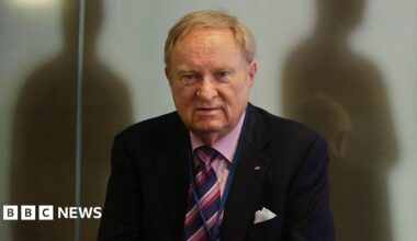 Ludwig Minelli, wearing a suit.