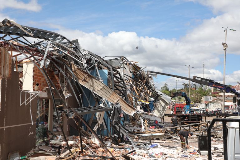 Heavy machinery cleans up the debris caused by the tornado with winds of up to 250 kilometers per hour that hit the city of Rio Bonito do Iguacu, Parana State, Brazil on November 8, 2025. A tornado killed at least six people and injured around 750 as it destroyed most of a town in southern Brazil, authorities said Saturday. The twister on Friday evening flipped cars like toys and wrecked buildings in Rio Bonito do Iguacu, a town of 14,000 people in Parana state, officials said. (Photo by Daniel Castellano / AFP)