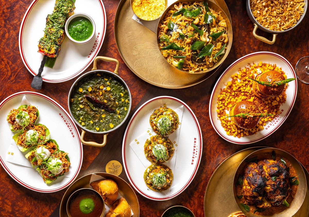 an array of indian bbq dishes from an indian festive menu presented on a table - biriyani, curry, and more