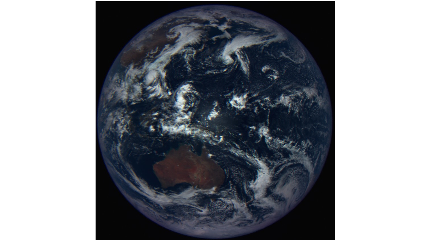 spacecraft photo of earth, showing australia surrounded by cloud-covered seas