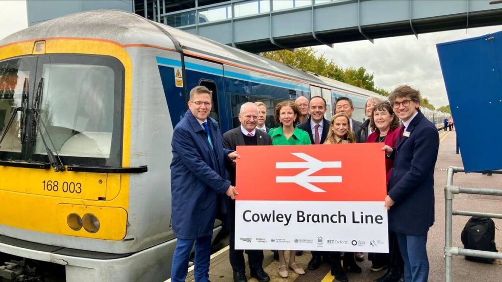 The Network Rail team holding up the sign for the soon to reopen Cowley Branch Line