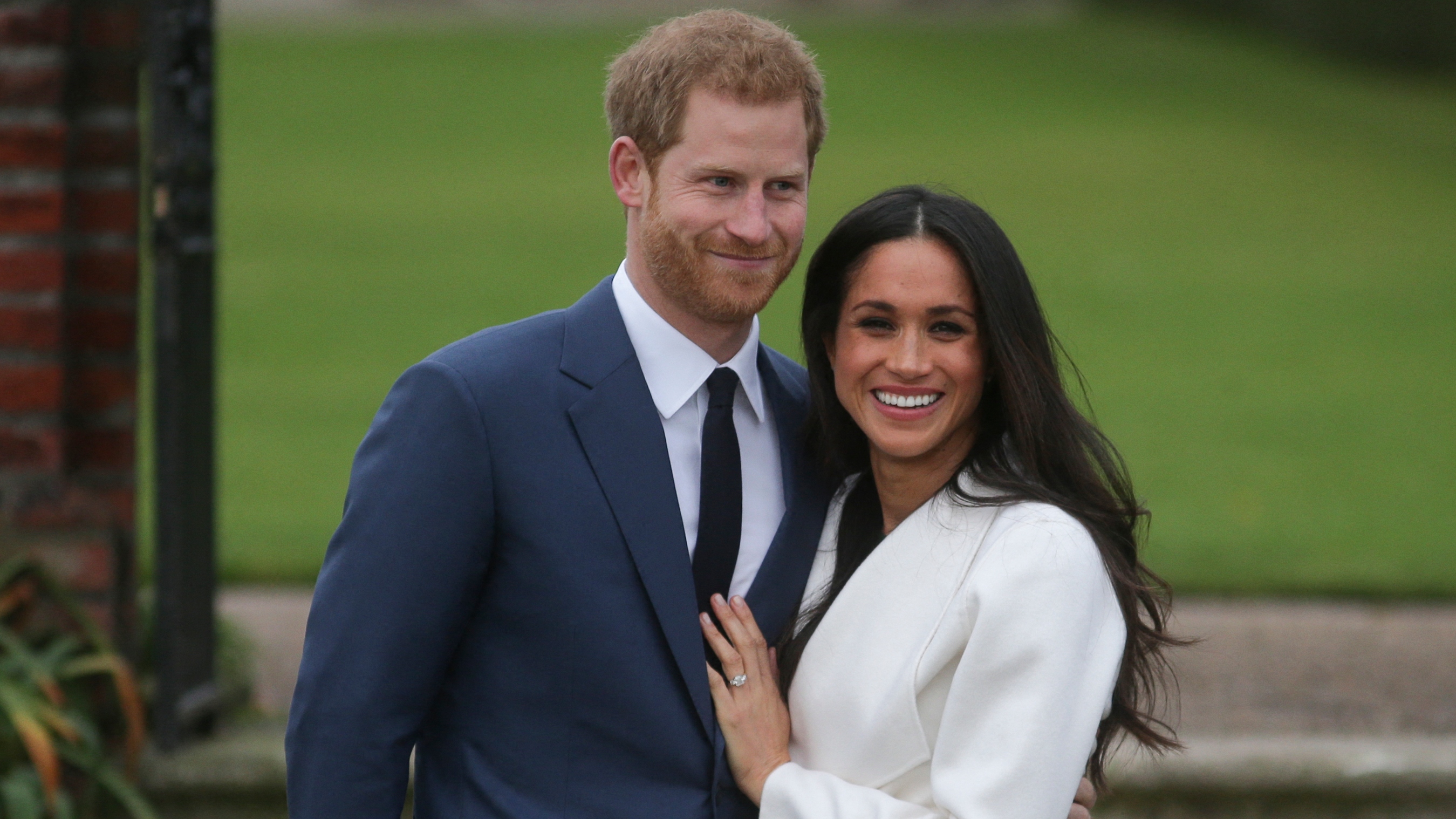 Prince Harry stands with his fianc&eacute;e US actress Meghan Markle as she shows off her engagement ring whilst they pose for a photograph in the Sunken Garden at Kensington Palace