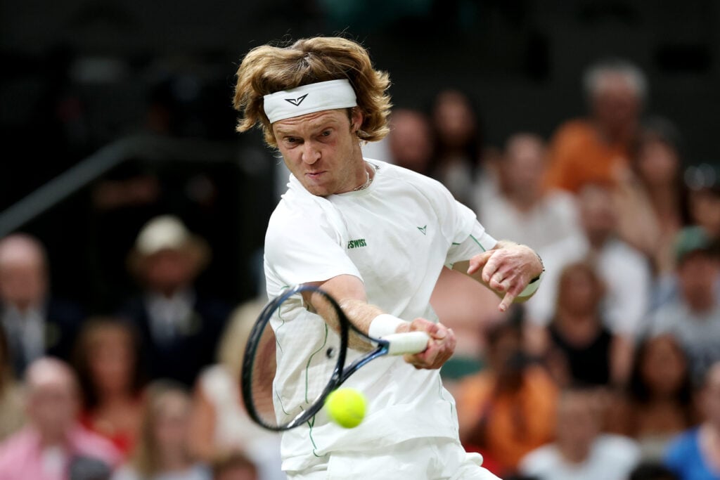 Andrey Rublev plays a forehand against Carlos Alcaraz in the fourth round of the 2025 Wimbledon Championships.