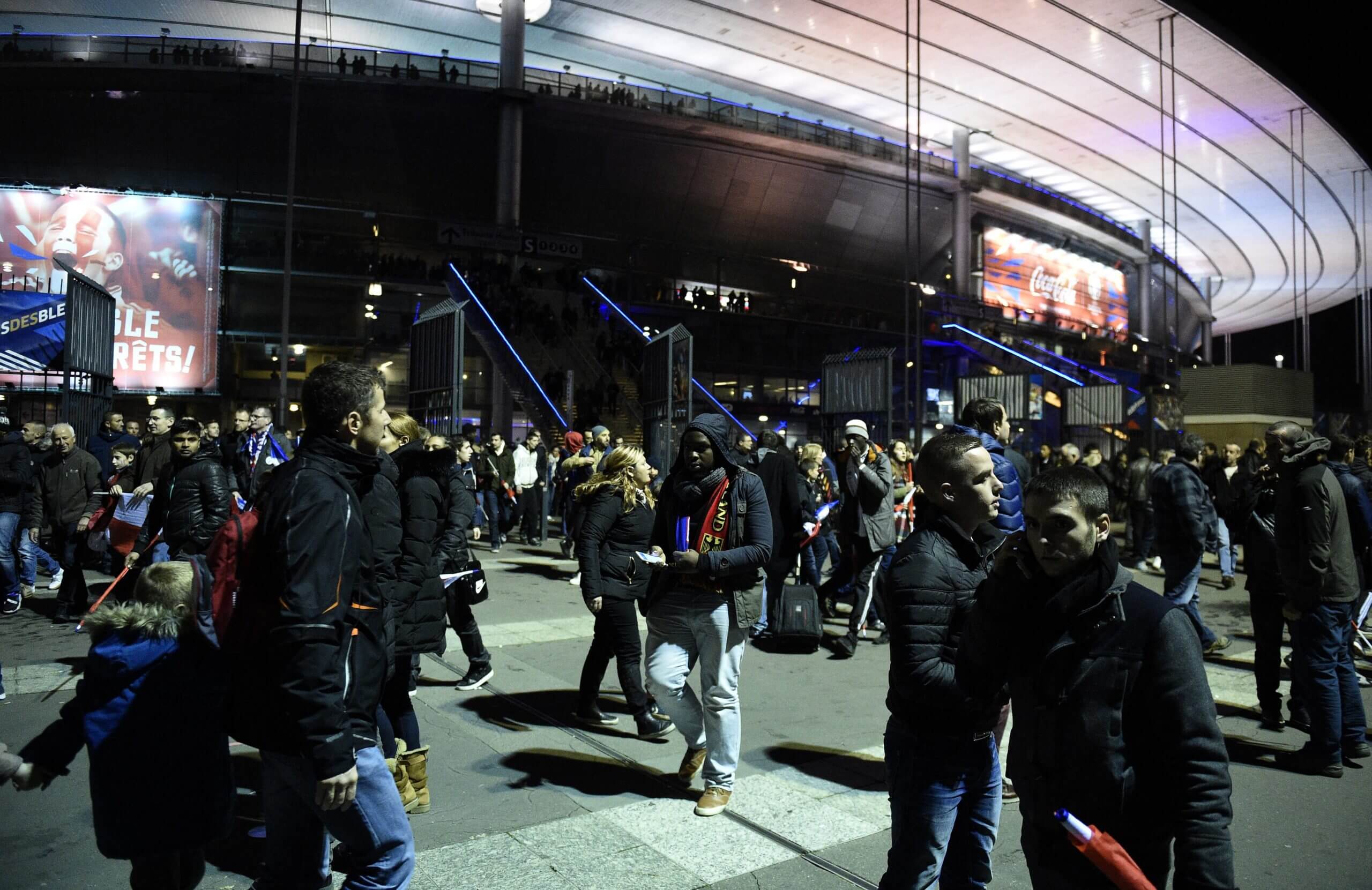 Spectators outside the Stade de France leave the scene after the stadium had been locked by authorities