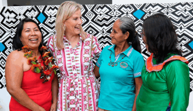 Duchess Sophie wearing a patterned shirt dress with her arms around three ladies and laughing