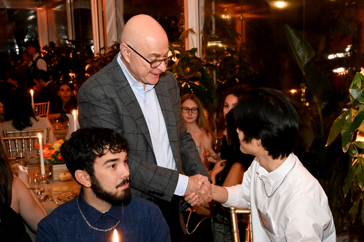 Northeastern University president Joseph Aoun shakes hand with a man in a white shirt