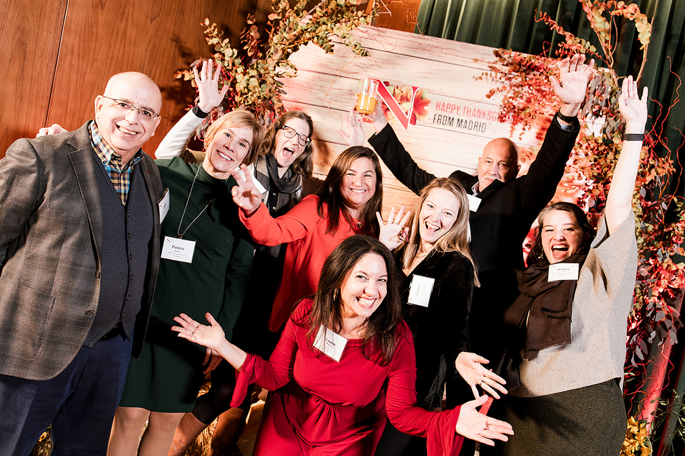 A group of people pose in front of a banner saying 'Happy Thanksgiving from Madrid'