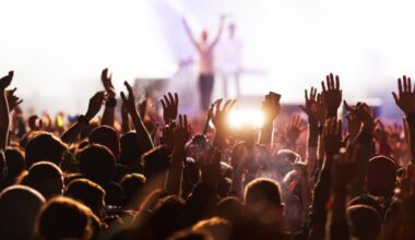 People in the audience holding their hands in the air during a concert.