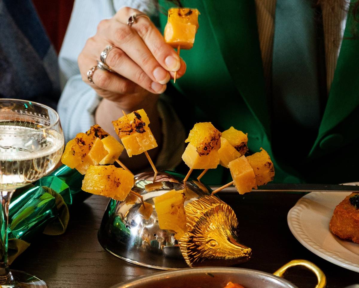 a pineapple hedgehog dish, with spears of pineapple poking out of a metal hedgehog ornament