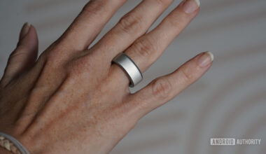 A user models their stilver Oura Ring 4.