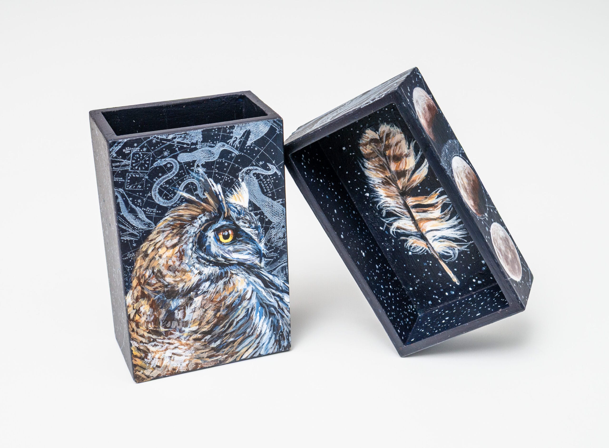 a matchbox by Christina Keith of an owl, feather, and constellation