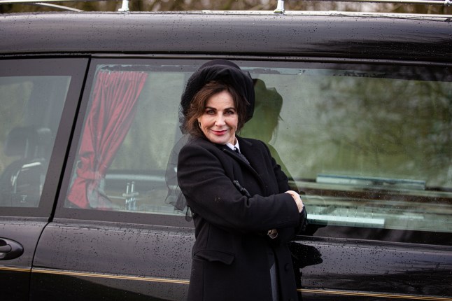 Sally Dexter standing outside a funeral car as Faith Dingle in Emmerdale