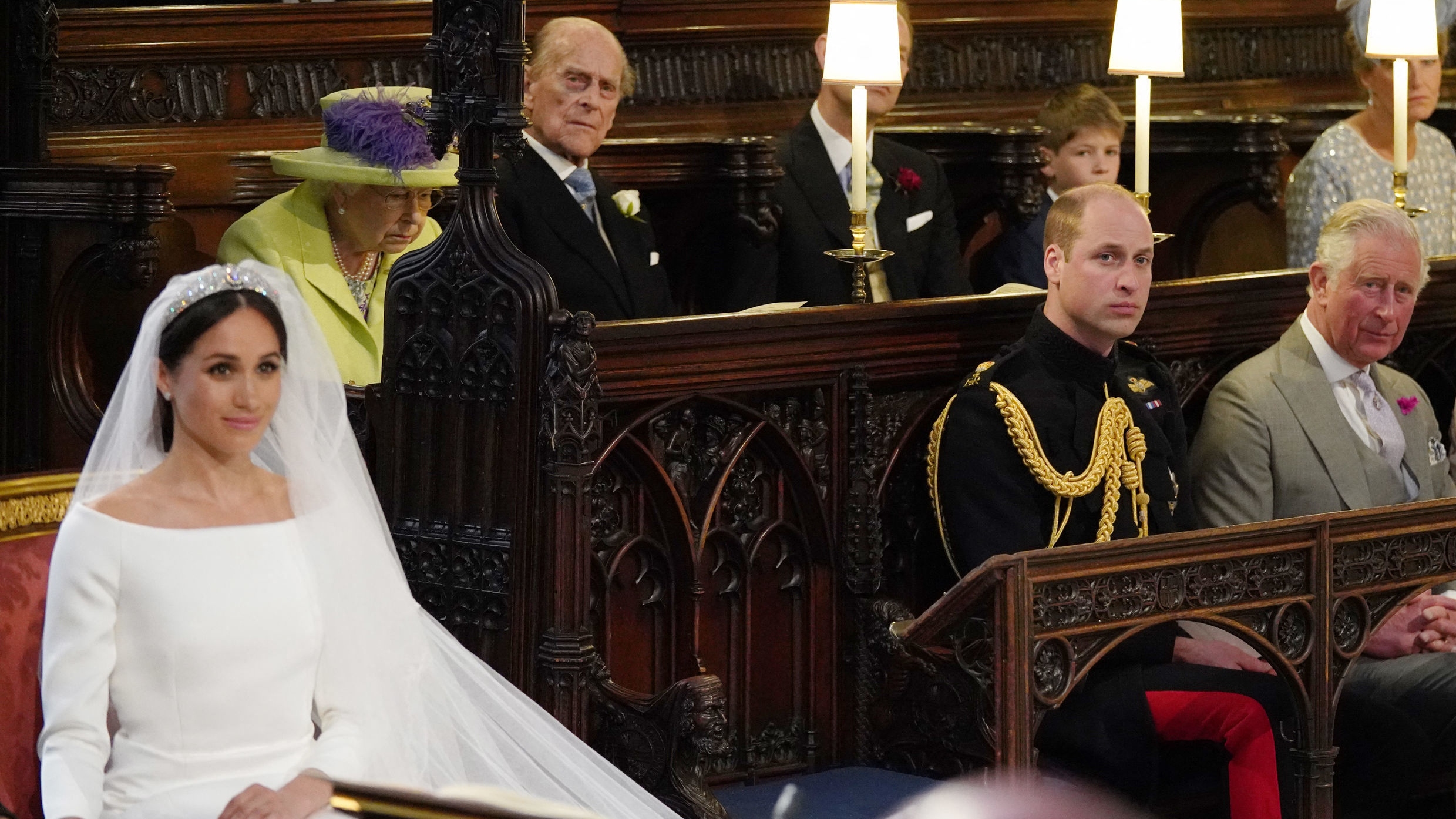 Meghan Markle sits in a white dress as the guests watch during her and Harry's wedding in St George's Chapel in 2018