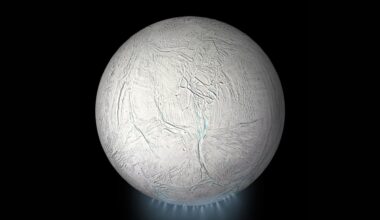 A photo of the moon Enceladus with a blue plume of steam underneath it as it sits in the darkness of space