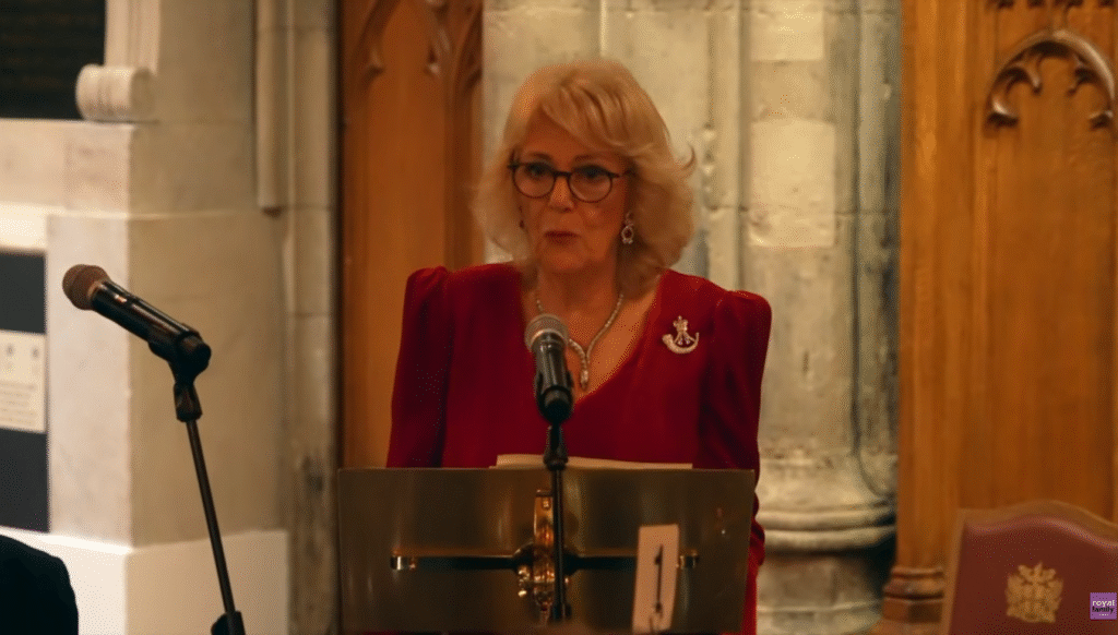 Queen Camilla giving a speech in a red dress