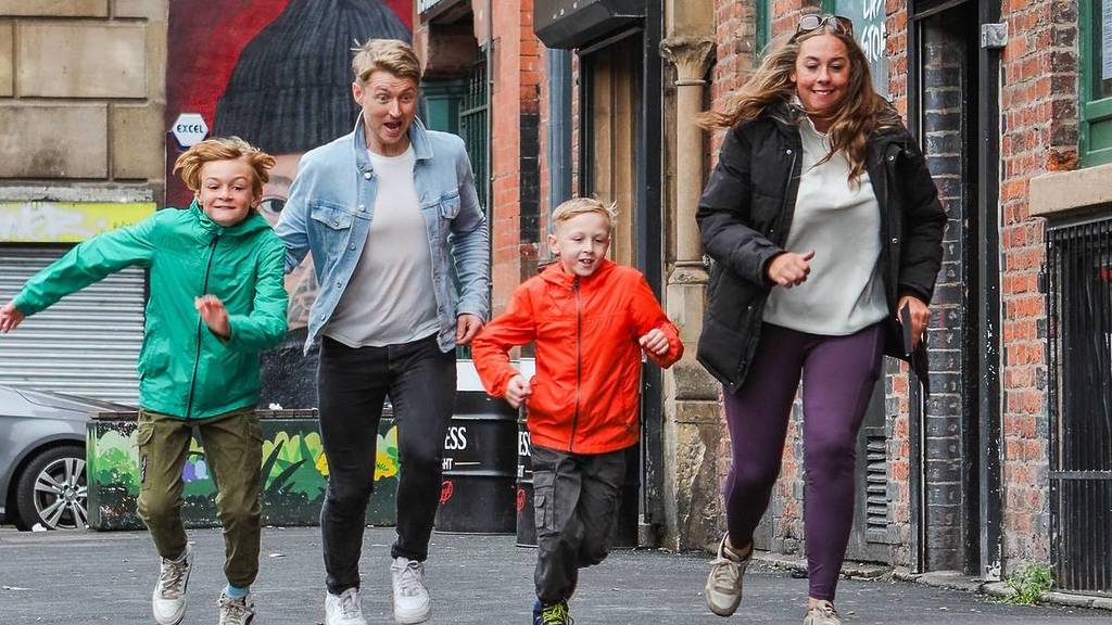 a family laugh as they run through London during the Race Across the World Experience