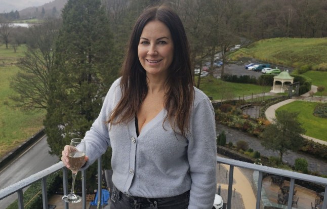 Victoria Abotorabi standing on a balcony with a glass of prosecco