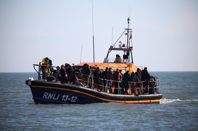 Migrants are brought ashore by the RNLI (Royal National Lifeboat Institution) after being rescued while crossing the English Channel, in Dungeness, Britain, March 15, 2022. REUTERS/Henry Nicholls