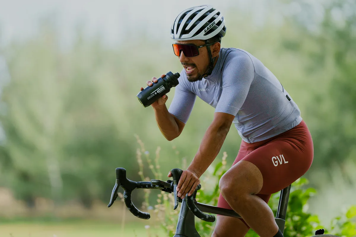 Man drinking from water bottle while riding a bike