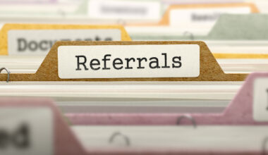 The word 'referrals' written on a divider in a filing cabinet