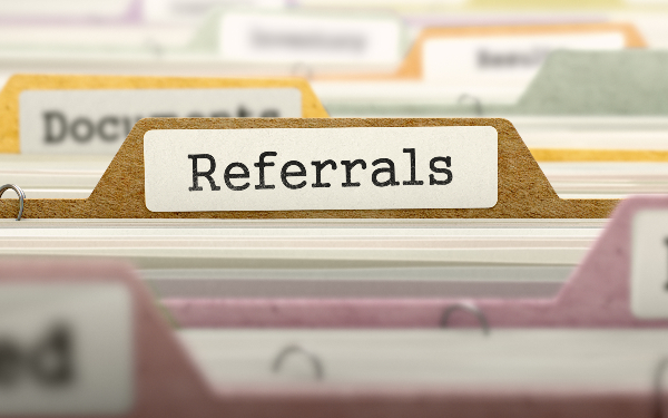 The word 'referrals' written on a divider in a filing cabinet