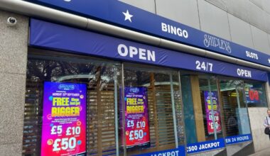 The outside of the 24-hour bingo hall. There are flashy adverts and signs saying 'open 24-hours' .