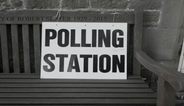 A picture of a sign saying "Polling Station" tied to a wooden bench. Photo by Steve Houghton-Burnett on Unsplash
