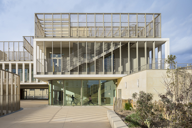 interlocking stone volumes sculpt layered school complex by brenac & gonzalez & associés