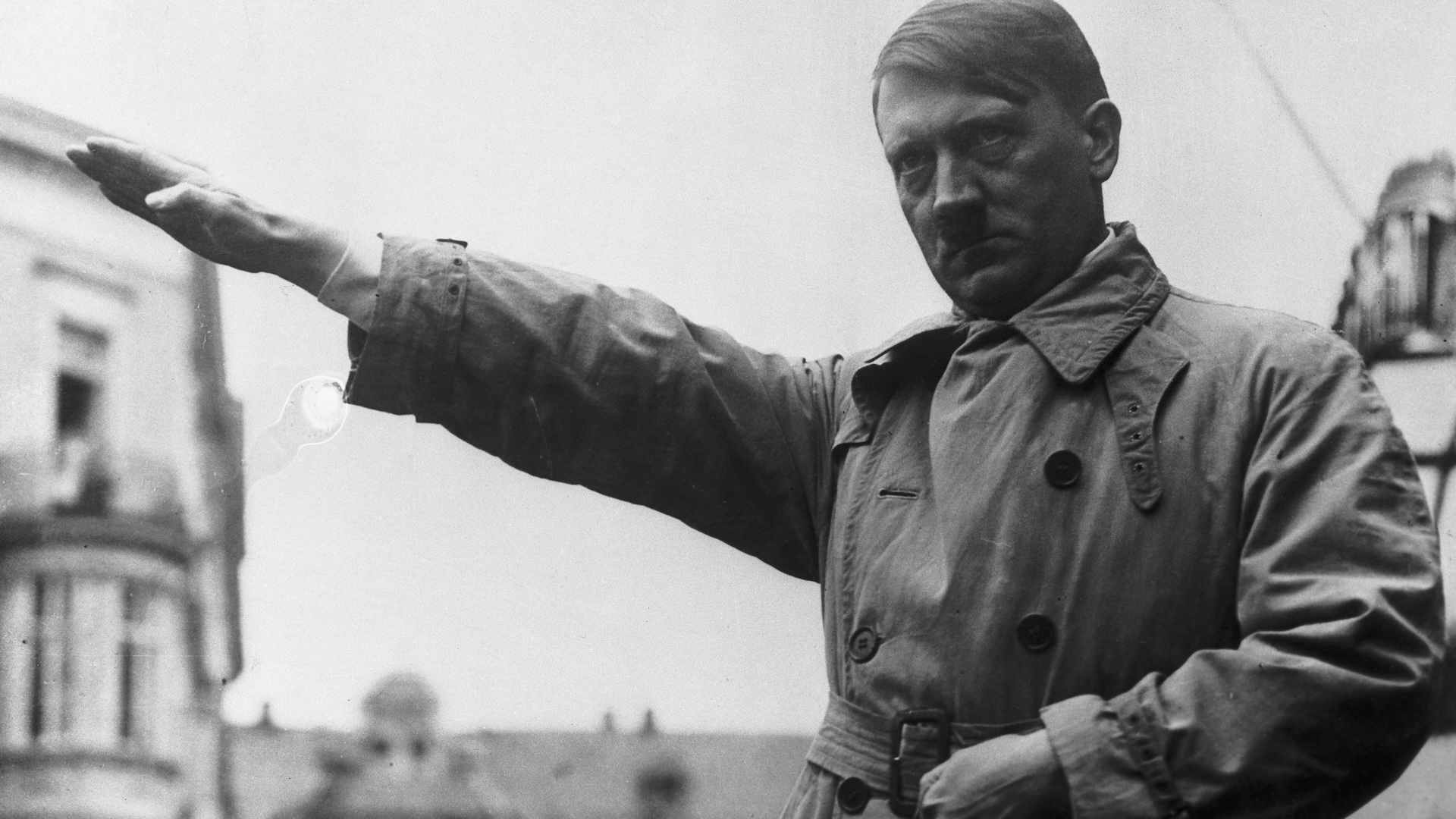 black and white image of dour hitler saluting
