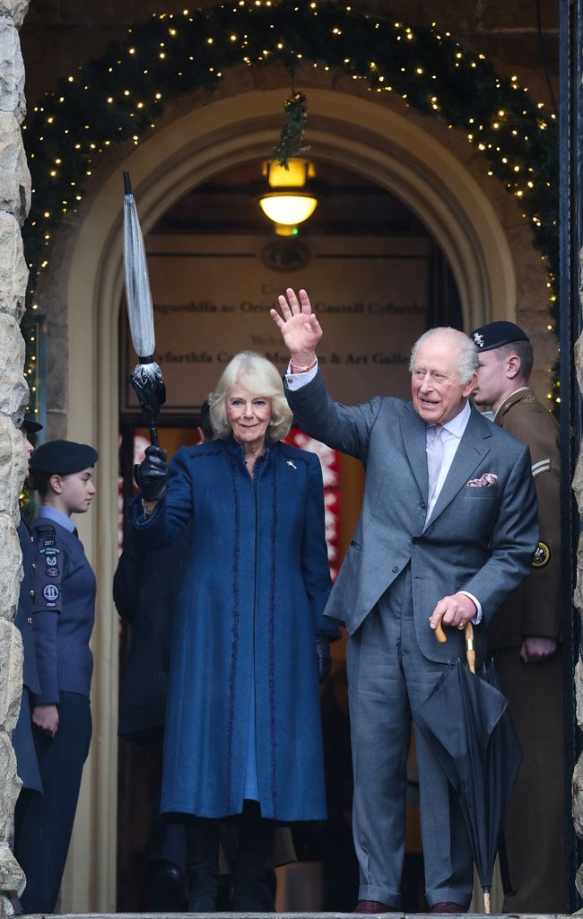 Queen Camilla and King Charles wave as they depart from a visit to Cyfarthfa Castle 