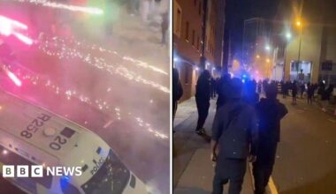 A photo of Nadia holding up her phone which shows Harkins tinder profile