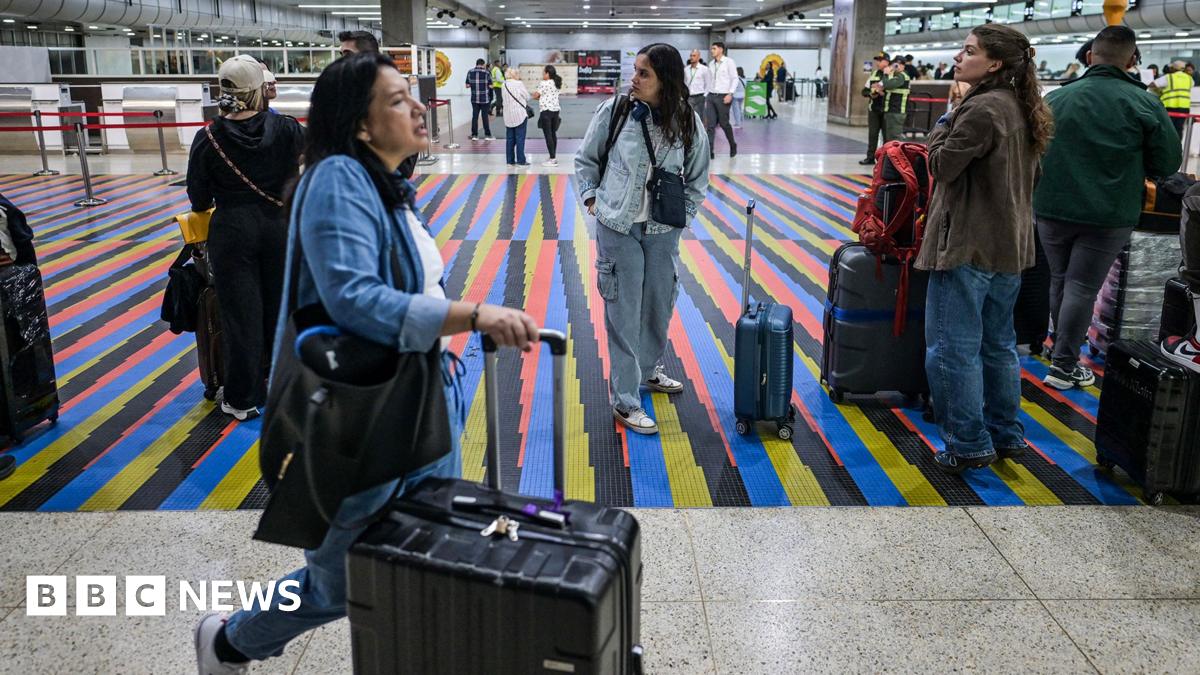 People queue to board a flight at Simon Bolivar International Airport in Maiquetia, near Caracas, Venezuela, 26 November 2025