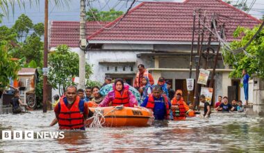 A rescue team evacuates women and children in a rubber boat, in West Sumatra, Indonesia