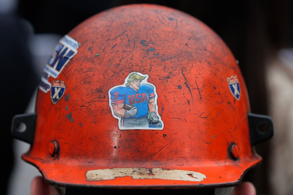 A member of the United Steelworkers union wears a sticker on his helmet depicting US President Donald Trump as an American football player during an event at the White House in April. Photo: TNS