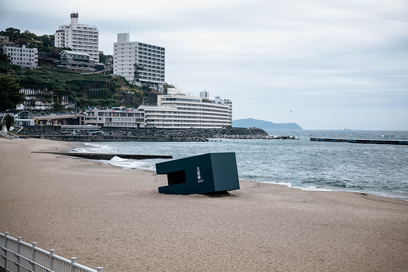 buried souvenir shop on japanese shoreline reflects on tourism, land, and memory