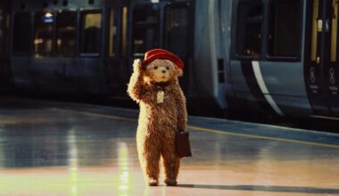 Paddington walking through a train station.