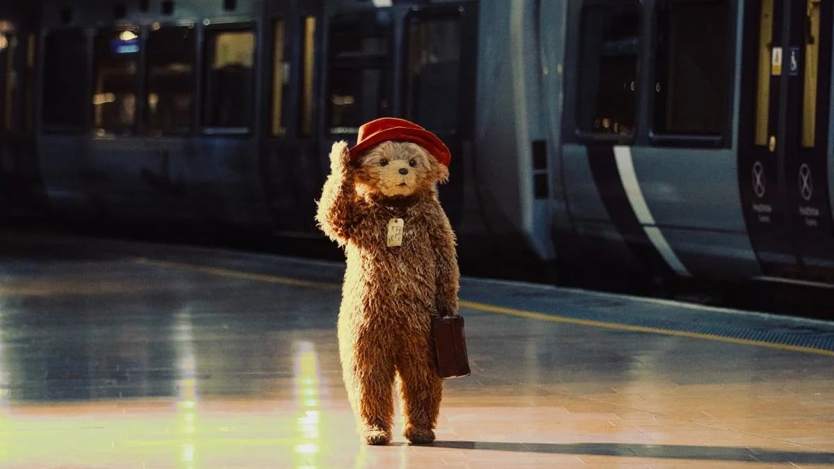 Paddington walking through a train station.