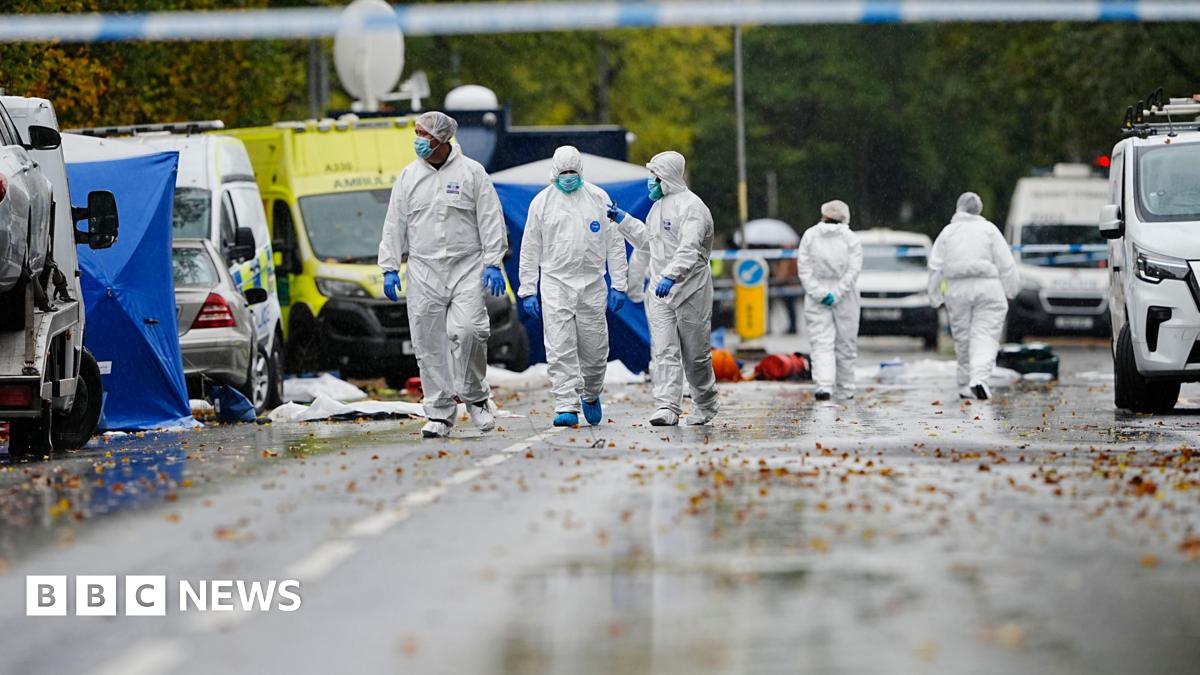Forensics search the streets surrounding the synagogue. Three officers wear white overalls, blue gloves and face masks