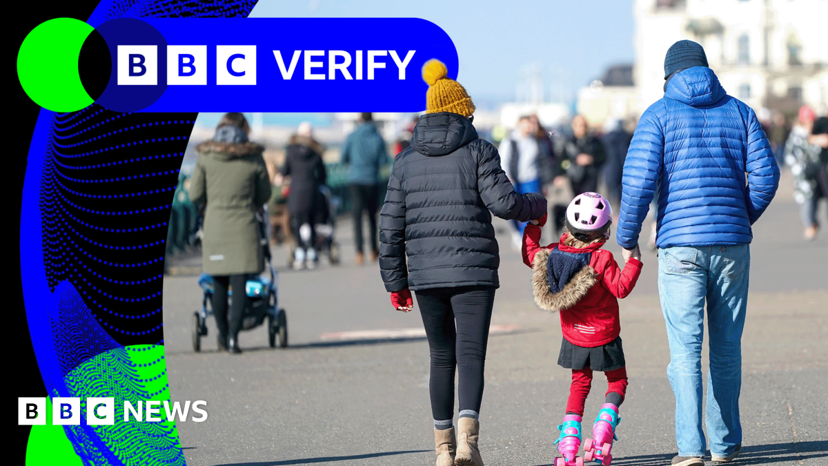 Young 18 year old man sits in the passenger seat of a black VW car, his arm resting on the open window as he looks to camera