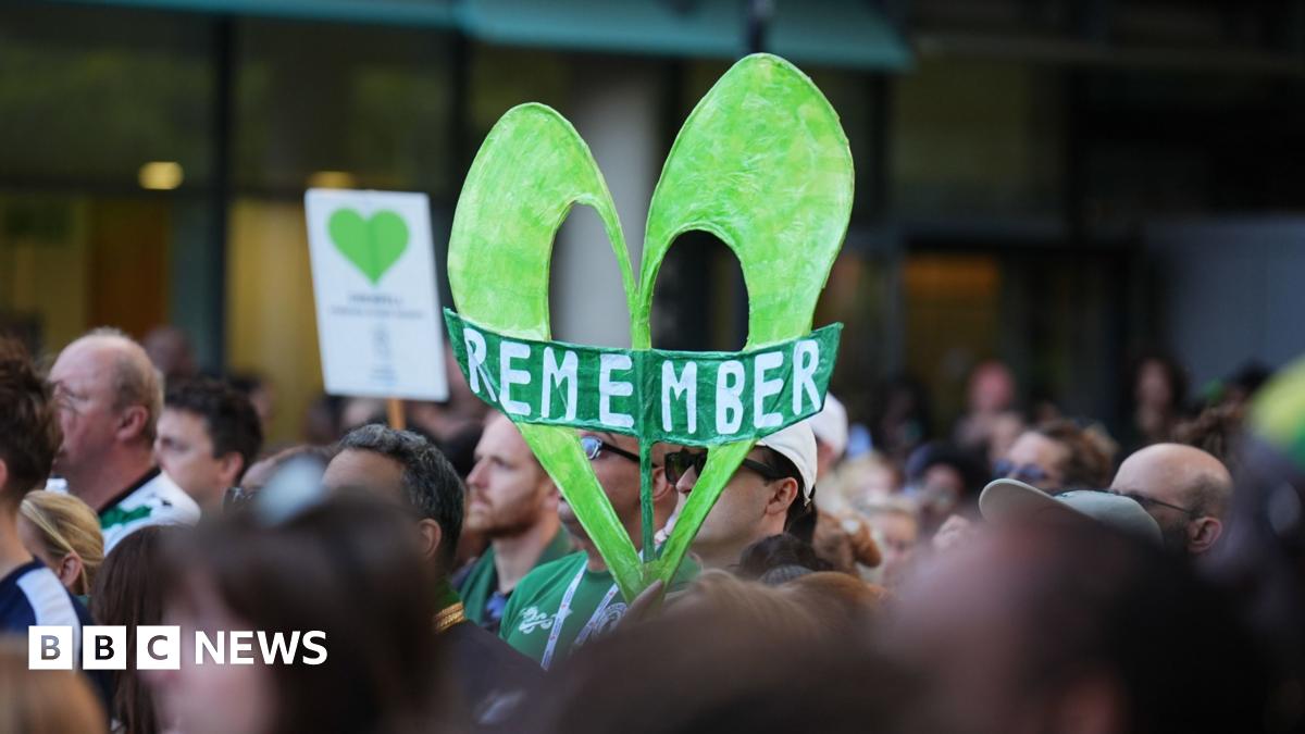 A crane is seen over the Grenfell Tower in west London where a large green heart is still visible on the top floors of the tower block