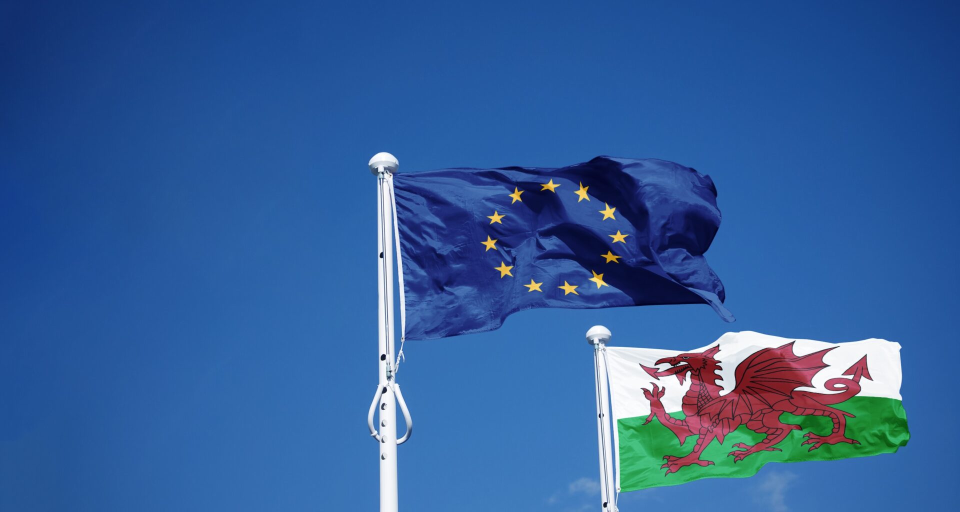 The article’s main image is of Welsh and EU flags against a blue sky.