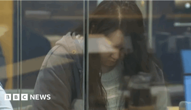Hakyung Lee, in a gray jacket and with her head bowed, in the dock at a court in Auckland, New Zealand