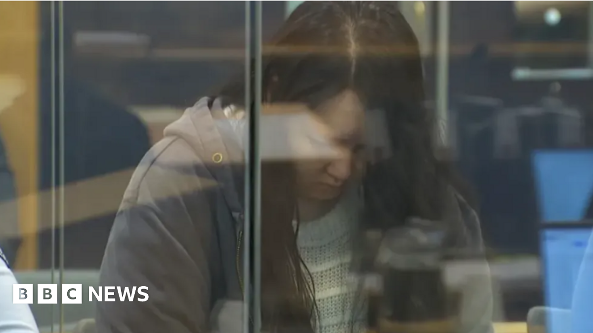 Hakyung Lee, in a gray jacket and with her head bowed, in the dock at a court in Auckland, New Zealand