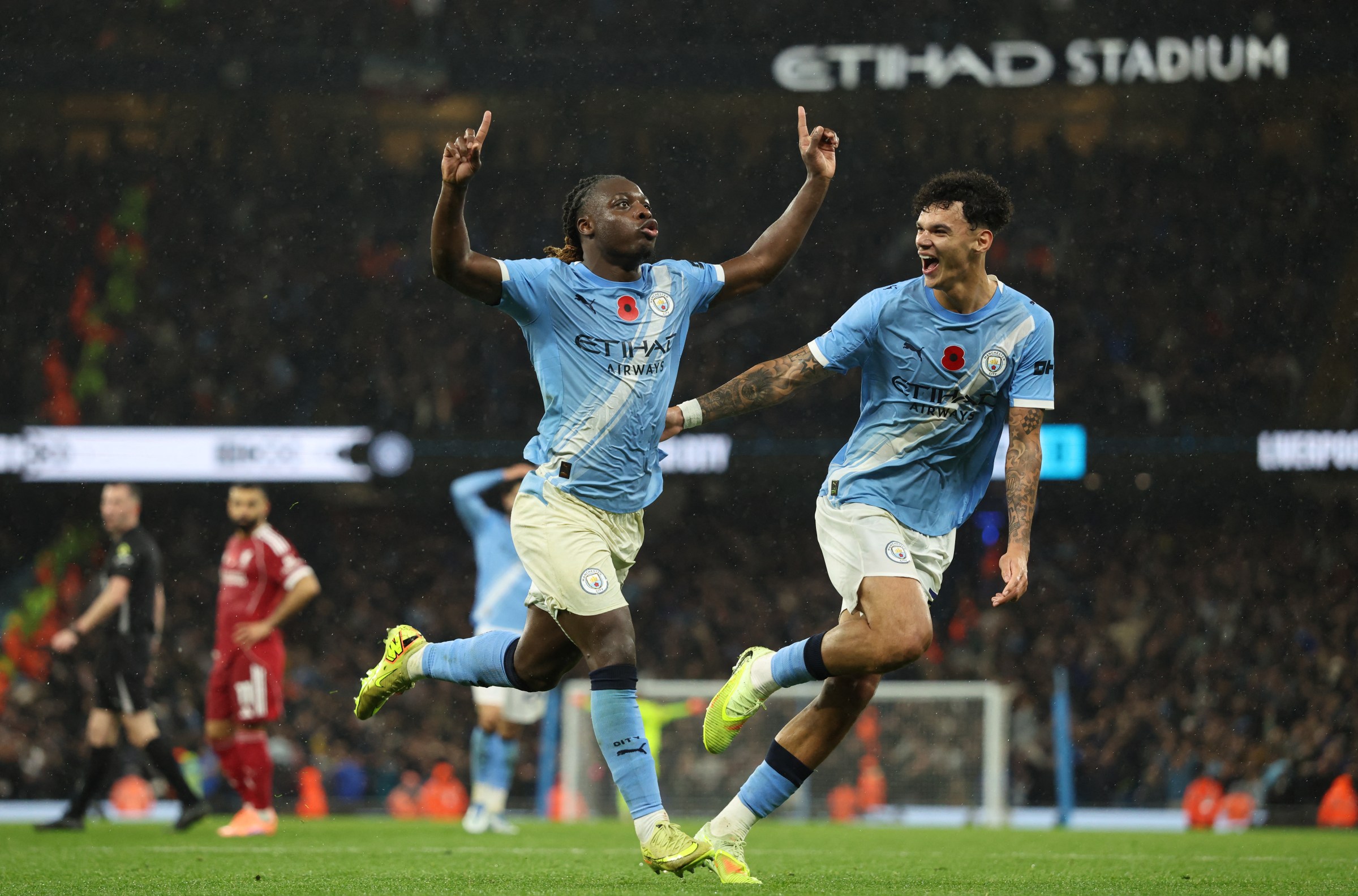 TOPSHOT - Manchester City’s Belgian midfielder #11 Jeremy Doku (L) celebrates scoring their third goal for 3-0 with Manchester City’s English midfielder #33 Nico O’Reilly (R) during the English Premier League football match between Manchester City and Liverpool at the Etihad Stadium in Manchester, north west England, on November 9, 2025. (Photo by Darren Staples / AFP) / RESTRICTED TO EDITORIAL USE. No use with unauthorized audio, video, data, fixture lists, club/league logos or ‘live’ services. Online in-match use limited to 120 images. An additional 40 images may be used in extra time. No video emulation. Social media in-match use limited to 120 images. An additional 40 images may be used in extra time. No use in betting publications, games or single club/league/player publications. / (Photo by DARREN STAPLES/AFP via Getty Images)