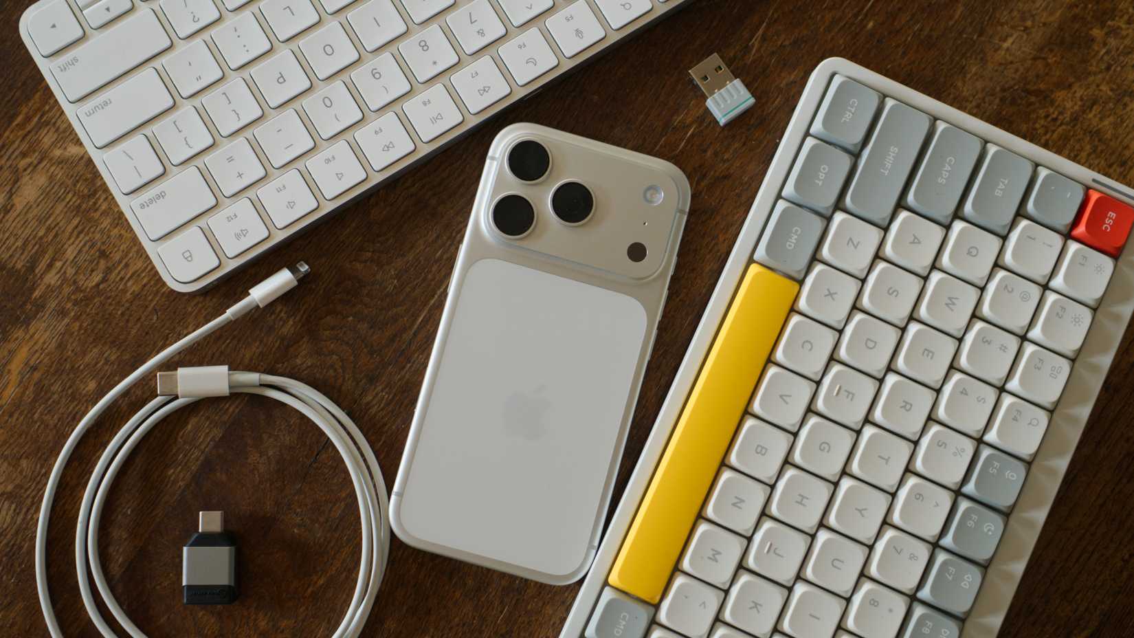 iPhone 17 Pro with Apple and NuPhy keyboards.