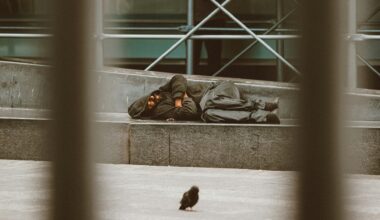 a homeless man lying down sleeping rough on the street