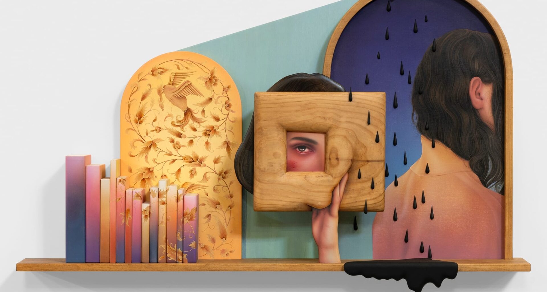 a work by Arghavan Khosravi of a woman holding up a wooden frame with an eye peering through and black raindrops surrounding them. there are colorful books and a black drip on the shelf below
